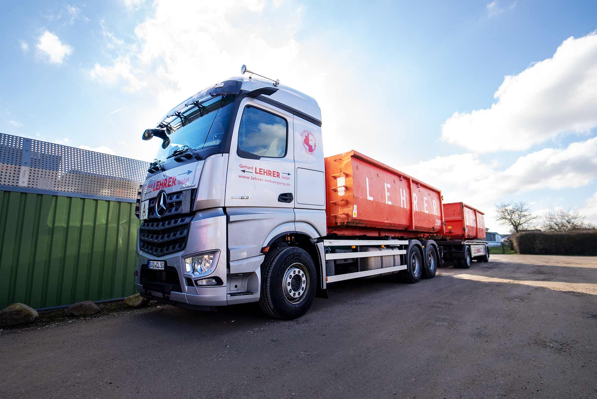 LKW mit Container vor dem Firmengelände